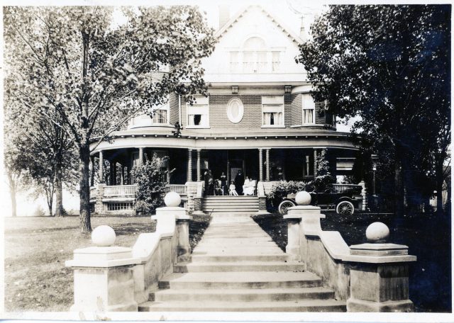 The Castle house at 518 West Jackson Street in St Marys, Ohio. Undated. John W. Kleinhenz and family on their front porch. The car is likely a Ford Model T Touring Car (circa 1910–1925). This house was owned and occupied by my great-grandfather John W. Kleinhenz and family from 1926-1944.